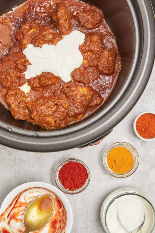 Savory chicken tikka masala in slow cooker with spices and cream.