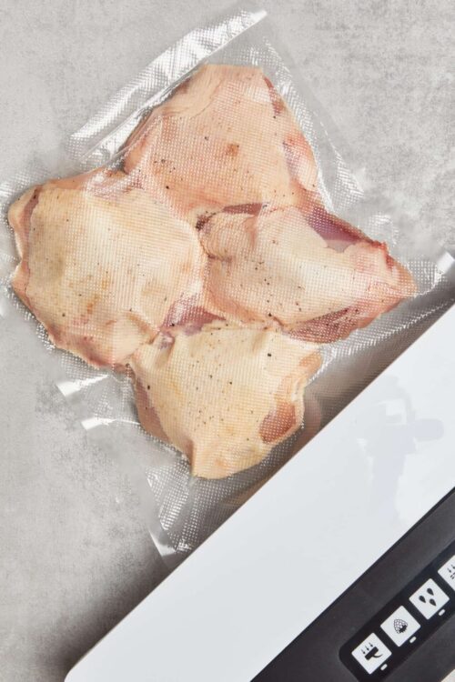 Raw chicken thighs vacuum sealed for cooking or meal prep.
