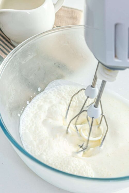 Freshly whipped cream in a stand mixer bowl, ready for dessert or toppings.