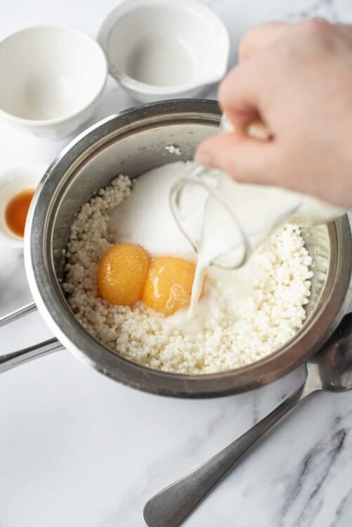 Cream, eggs, sugar, vanilla extract in mixing bowl for baking recipe.