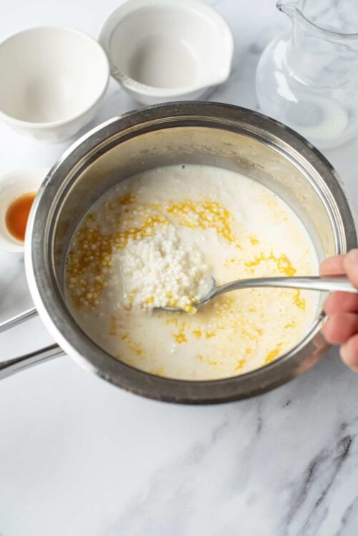 Creamy custard mixture being stirred in a saucepan.
