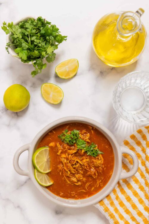 Crockpot chicken tortilla soup served with lime slices and fresh cilantro. Perfect for easy, flavorful dinners.