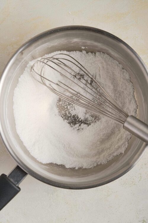 Flour mixture in mixing bowl with whisk for baking or cooking.