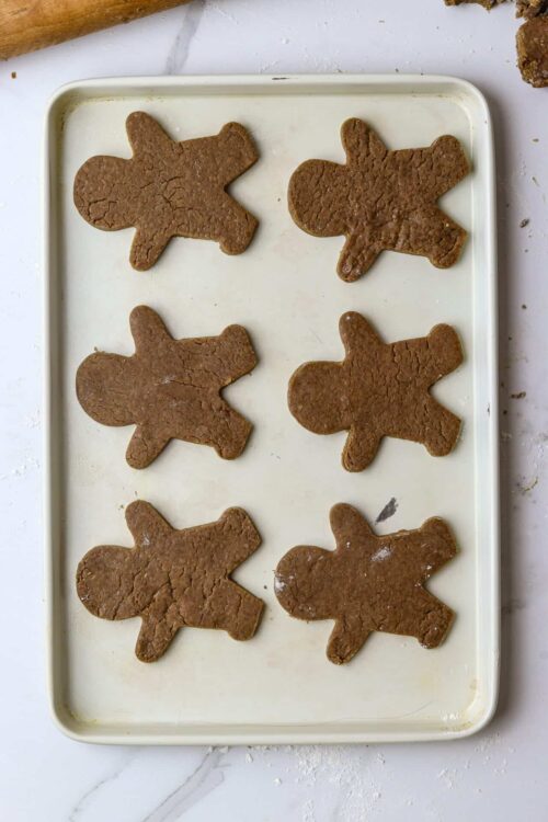 Gingerbread cookies on a baking sheet ready to be baked.