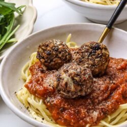 Savory Italian meatballs with spaghetti and marinara sauce in a white bowl.
