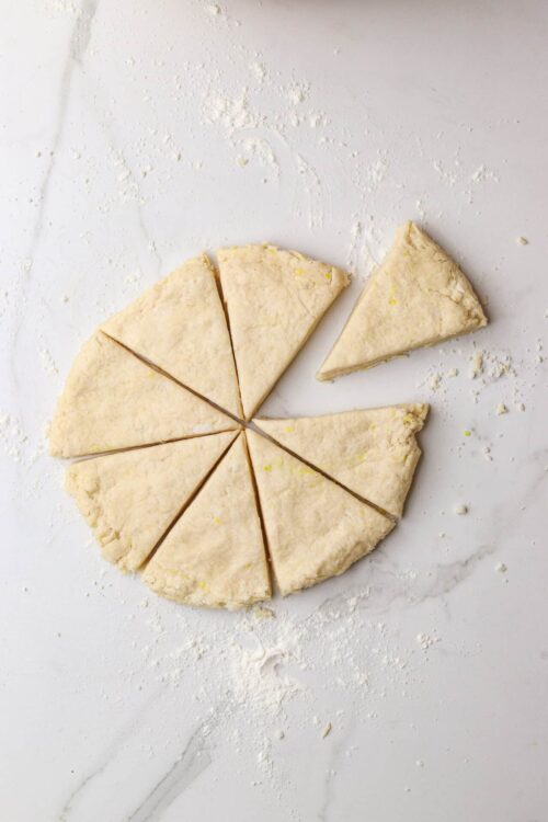 Buttery pie crust dough prepped for baking on white marble surface.