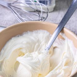 Silky smooth homemade whipped cream in a beige bowl for baking and desserts.
