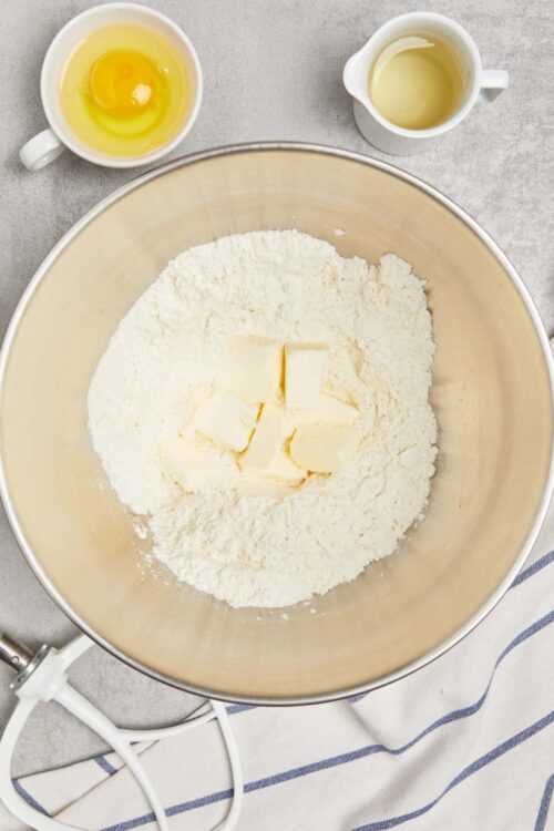 Flour, butter, eggs, and milk in a mixing bowl for baking recipe.