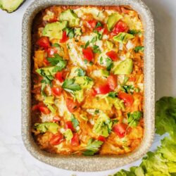 Savory baked casserole with avocado, tomatoes, and herbs in a baking dish.