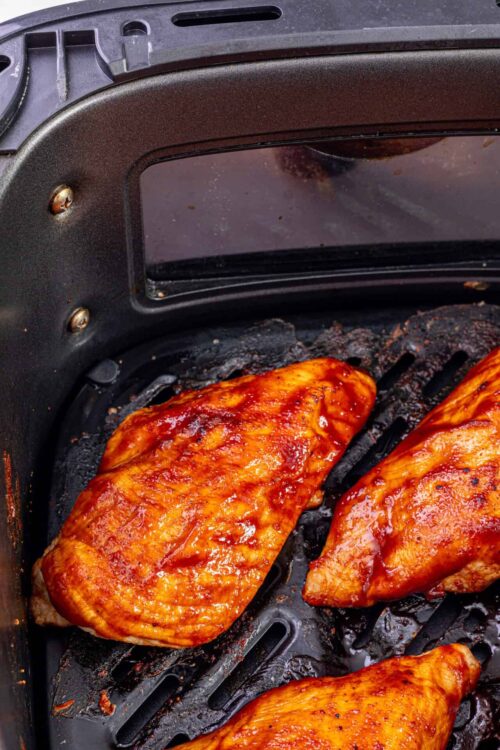 Baked chicken breasts on air fryer grill rack.