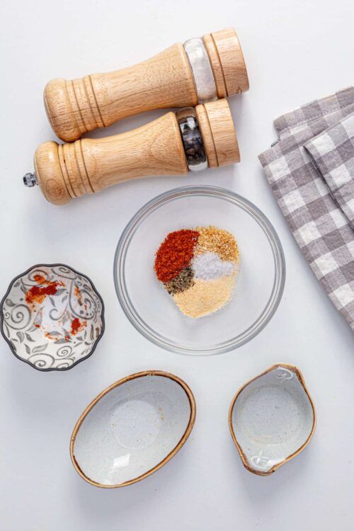 Ground spice and herb mixture for baking seasoning blend, with salt and pepper shakers.