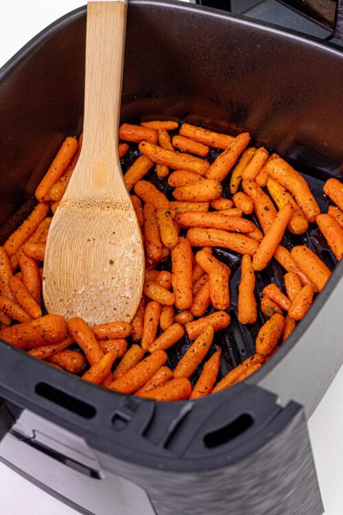 Roasted baby carrots in an air fryer with black pepper and herbs.