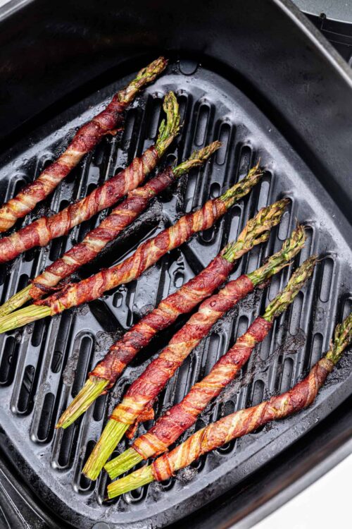 Bacon-wrapped asparagus spears cooked in an air fryer for crispy, flavorful healthy appetizer or side dish.