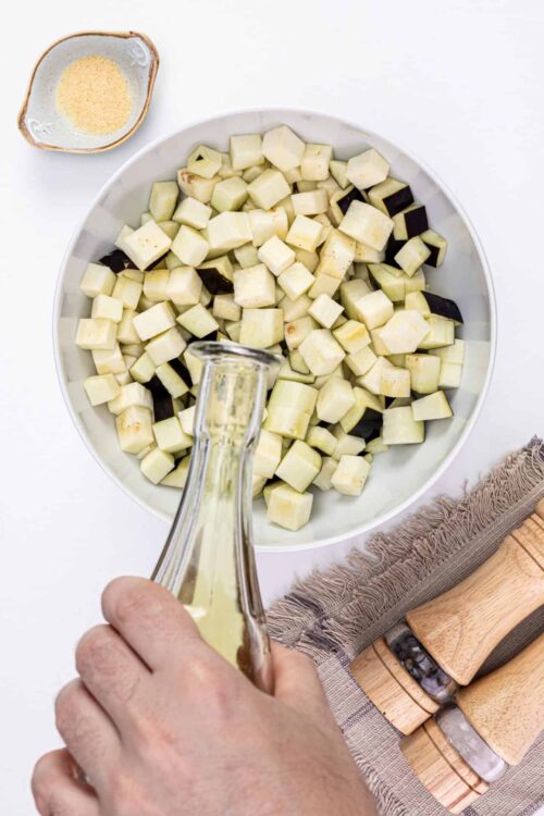 Cubed eggplant in a white bowl for baking recipes.
