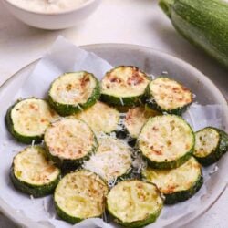 Grilled zucchini with cheese served on a white plate.