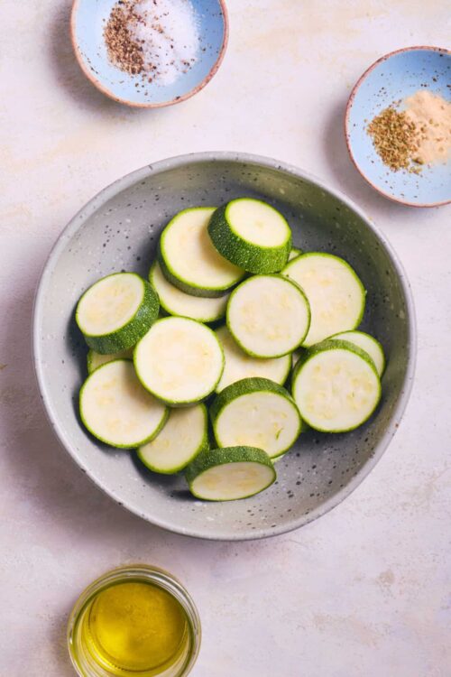 Fresh sliced zucchini in a white bowl, ready for cooking or baking.