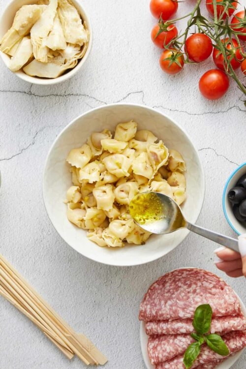 Creamy pasta with olive oil and cherry tomatoes on light background, fresh ingredients, Baked Bree.