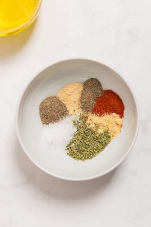 Ground spices in a white bowl for seasoning recipes.