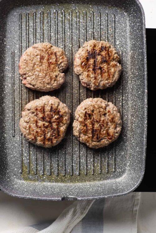 Juicy burger patties grilling on a non-stick skillet, ready for a delicious homemade burger.