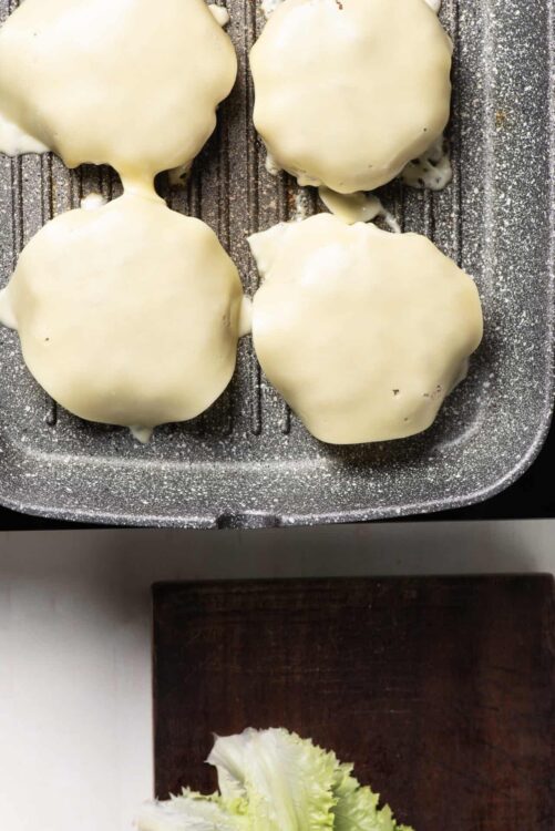 Golden white chocolate-covered cookies on baking sheet.