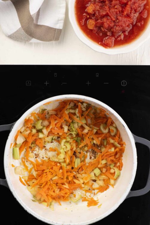 Savory vegetable soup ingredients cooking in a pot at home.