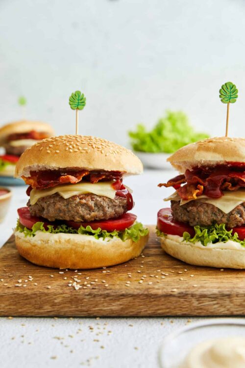 Juicy homemade bacon cheeseburgers with lettuce, tomato, and cheese on sesame seed buns.