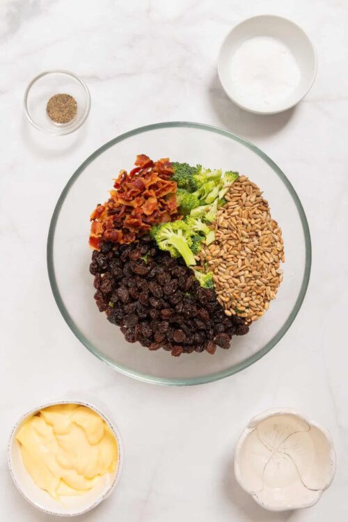 Savory dried fruit mixture with bacon broccoli sunflower seeds and cranberries in glass bowl.