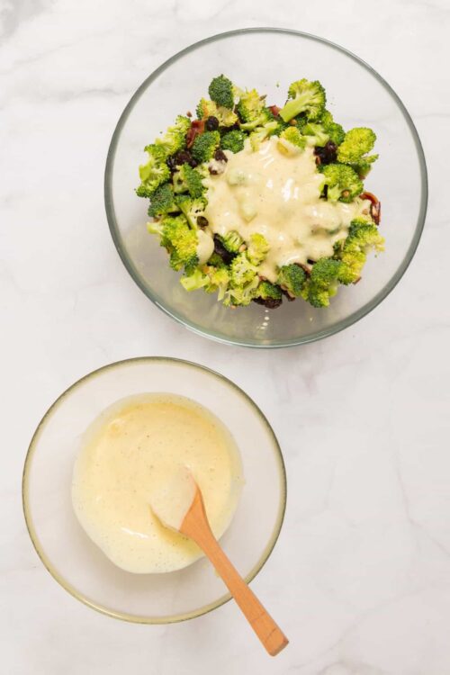 Broccoli salad with creamy dressing in glass bowl, on white marble surface, healthy side dish, fresh vegetables, easy recipe.