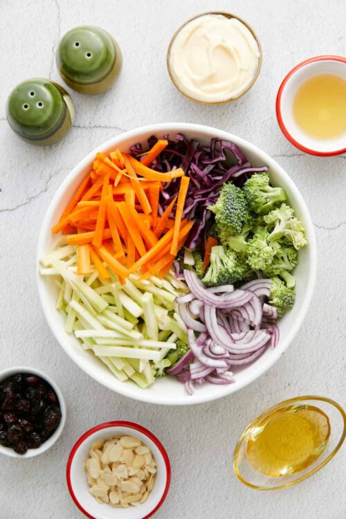 Sliced vegetables including carrots, purple cabbage, broccoli, and onions for healthy Asian stir-fry.