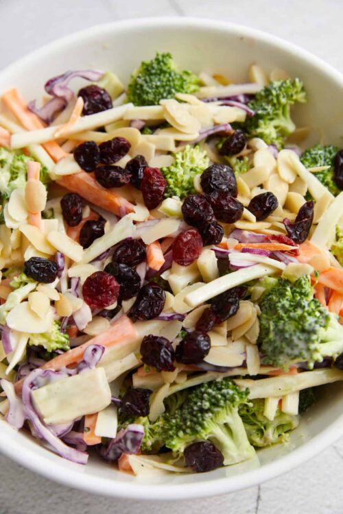 Fresh vegetable salad with broccoli, shredded cabbage, carrots, almonds, dried cranberries, and cheese crumbles.