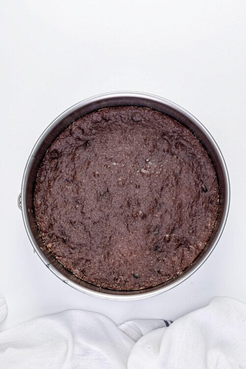 Rich chocolate cookie crust in a round baking pan.
