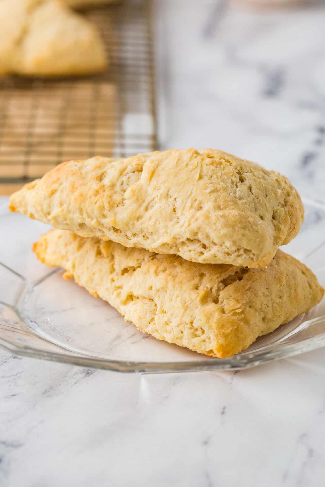 Fluffy lemon scones with a golden crust on a glass plate, perfect for breakfast or tea.