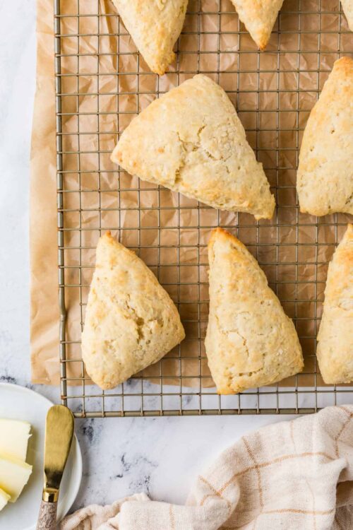 Flaky scones cooling on wire rack, baked fresh for breakfast or tea.