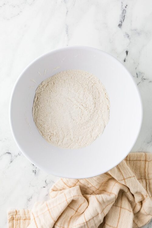 All-purpose flour in a white bowl for baking recipes.