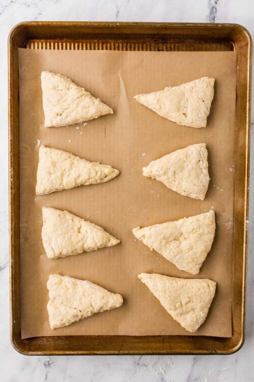 Butter scones dough triangles on baking sheet, ready to bake.
