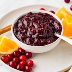 Sweet homemade cranberry sauce served with orange slices and cinnamon stick. Perfect holiday side dish.