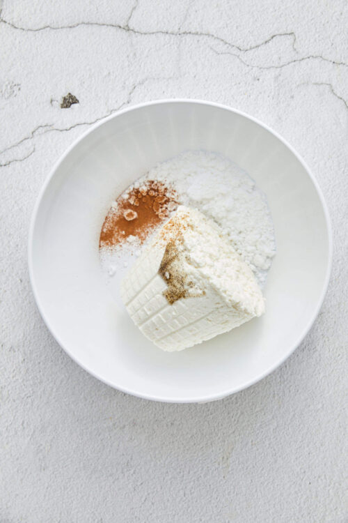 Cream cheese with spices in a white bowl for baking recipes.