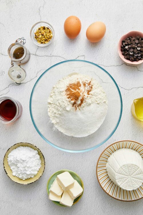 Flour and baking ingredients for homemade baking on a white textured surface.