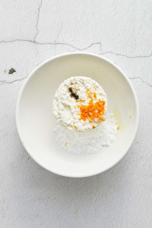 Flour, eggs, and seasonings in a white bowl for baking preparation.