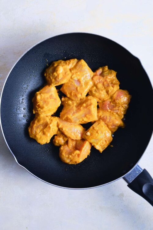 Creamy chicken curry cooking in a black skillet, savory and flavorful, step-by-step recipe for homemade chicken curry.