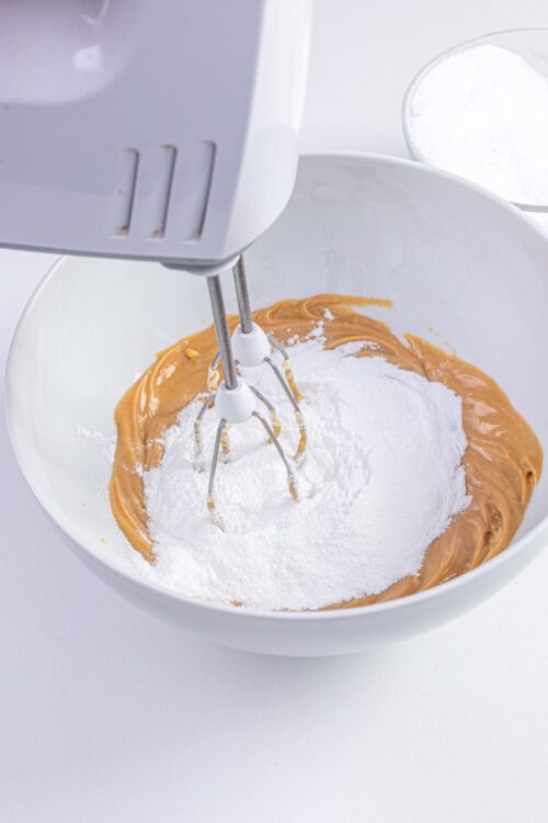 Flour and peanut butter mixture in a mixing bowl with an electric hand mixer.