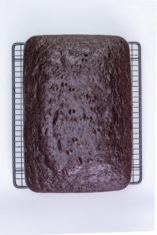 Moist chocolate cake cooling on a wire rack, perfect for homemade baked desserts.