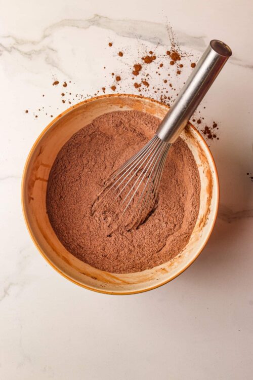 Crushed chocolate cookies in a mixing bowl with a whisk for baking or dessert recipes.