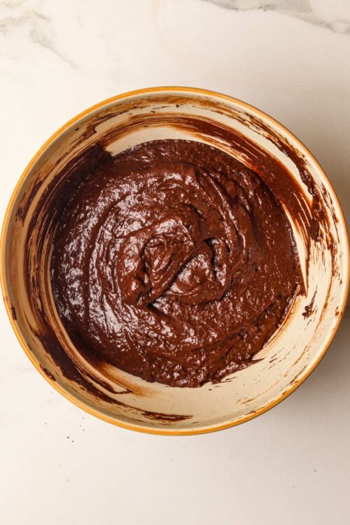 Smooth chocolate cookie dough in a mixing bowl ready for baking.