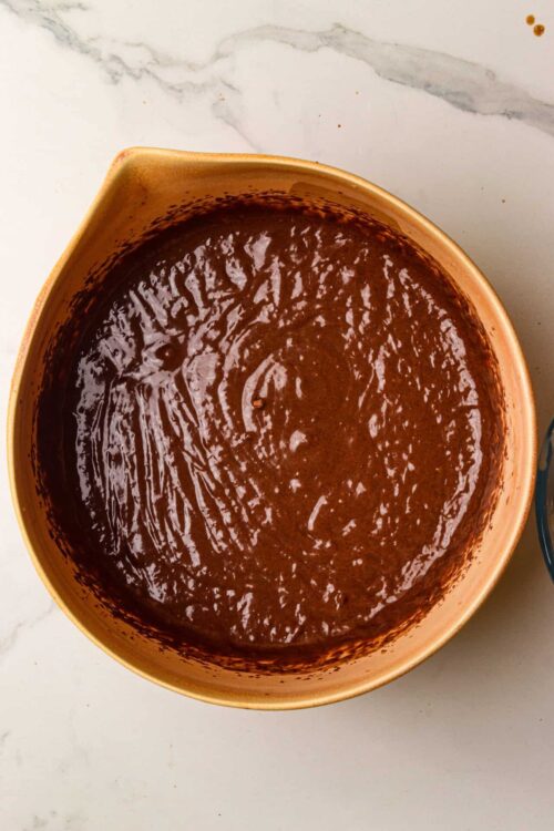 Fudgy chocolate cake batter in a ceramic mixing bowl.