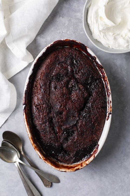 Creamy baked dessert with caramelized top in oval baking dish.