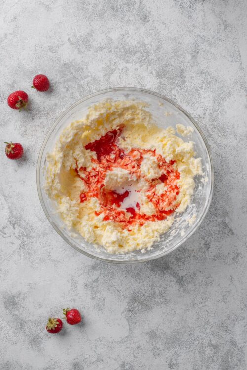 Cream cheese and strawberry jam mixture in glass bowl for baking or dessert recipes.