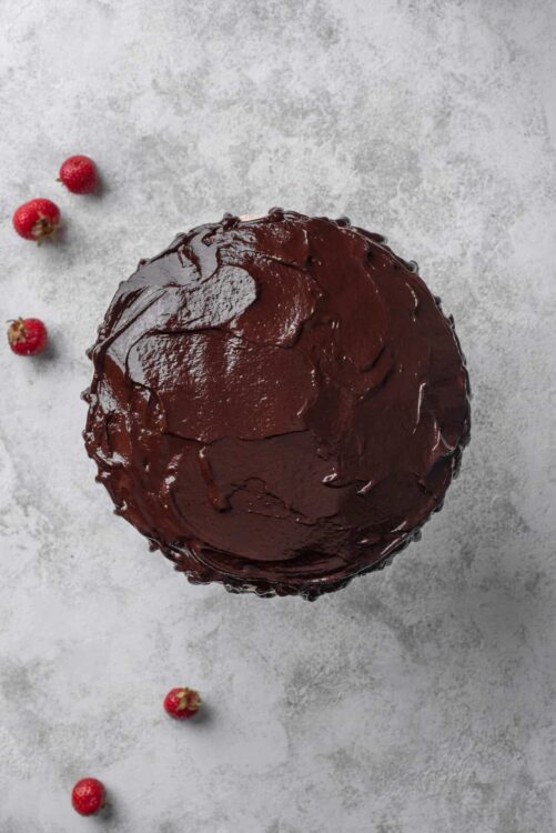 Decadent chocolate cake with rich frosting and fresh strawberries on the side. Perfect for dessert or special occasions.