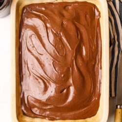 Rich chocolate frosting spread evenly in a baking dish.