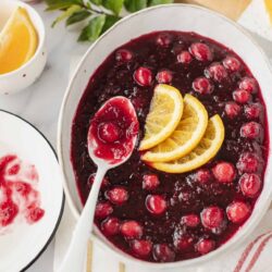 Fresh cranberry orange sauce with slices of orange and whole cranberries in a white serving dish.